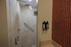 a bathroom with a shower with a glass door at Fiesta Inn Nogales in Nogales