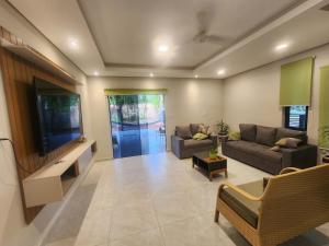 a living room with a couch and a flat screen tv at La Calma San Bernardino in San Bernardino
