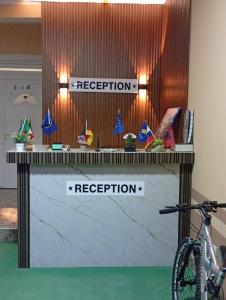 a reception desk with two signs for inspection and a bike at Grandino rooms & apartments in Ulcinj