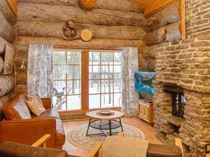 a living room with a couch and a stone fireplace at Holiday Home Luppokelo by Interhome in Saariselka