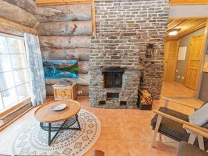 a living room with a stone fireplace and a table at Holiday Home Luppokelo by Interhome in Saariselka
