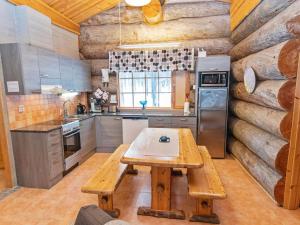 a kitchen with a wooden table and a refrigerator at Holiday Home Luppokelo by Interhome in Saariselka