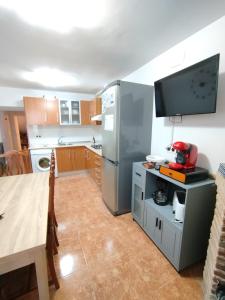 a kitchen with a stainless steel refrigerator and a table at VILLA ROBLES in Santisteban del Puerto