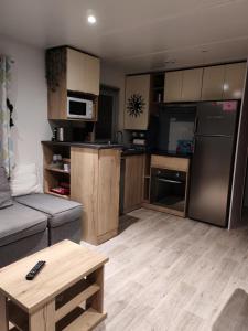 a living room with a couch and a kitchen at Le Havre de la jungle in Montereau