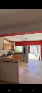 a large kitchen with a refrigerator and a tile floor at Bela house in Concepción del Uruguay