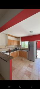 a large kitchen with a red stripe on the ceiling at Bela house in Concepción del Uruguay +10 photos