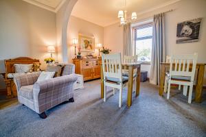 ein Wohnzimmer mit Tisch, Stühlen und Sofa in der Unterkunft Kylelachin in Dingwall