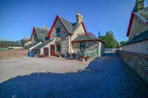 ein Haus mit einer steinernen Auffahrt davor in der Unterkunft Kylelachin in Dingwall