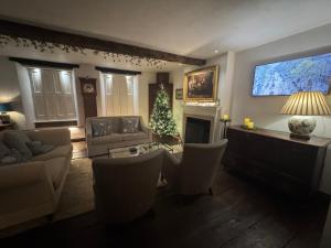 ein Wohnzimmer mit einem Weihnachtsbaum und einem Fernseher in der Unterkunft The Old Wheatsheaf in Towcester