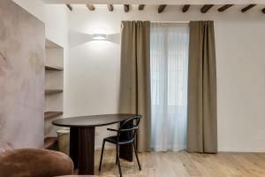 a table and chairs in a room with a window at Il Fiore del Prione in La Spezia