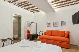a living room with an orange couch and a tv at Il Fiore del Prione in La Spezia