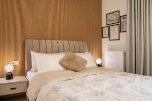 a bedroom with a large bed with two lamps on it at Ophelia's - Luxury Apartment in Volos