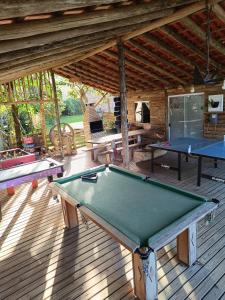 a patio with two ping pong tables on a deck at Cabana Canadense, Vem Relaxar e Desconectar in Imaruí