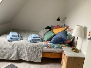 a bed with colorful pillows on it in a room at Annekset - Bjørnø in Faaborg
