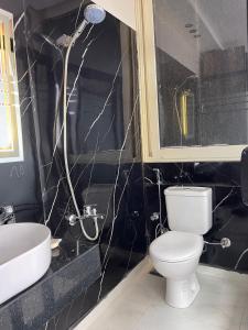 a black bathroom with a toilet and a sink at Cloud pyramids view inn in ‘Ezbet `Abd el-Ḥamîd