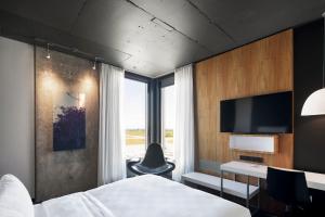 ein Schlafzimmer mit Bett, Schreibtisch und Fernseher in der Unterkunft Alt Hotel Halifax Airport - In Terminal in Enfield