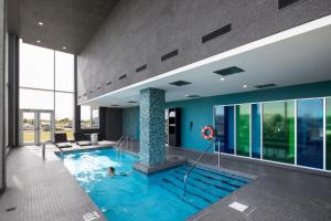 ein Pool in einem Gebäude, in dem eine Person schwimmt in der Unterkunft Alt Hotel Halifax Airport - In Terminal in Enfield