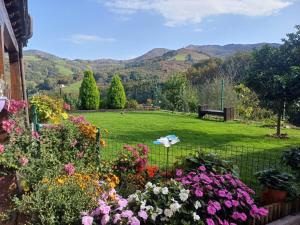 a garden with flowers and a park with a bench at El eco de los robles in Sumbilla