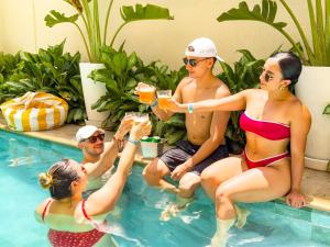 a group of people sitting in the pool drinking drinks at Hotel Valladolid in Santa Marta