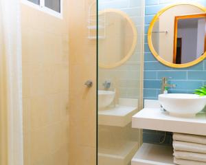 a bathroom with a sink and a glass shower at Hotel Valladolid in Santa Marta