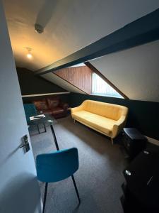 a room with a bed and a blue chair in it at Rhyl Aparthotels in Rhyl
