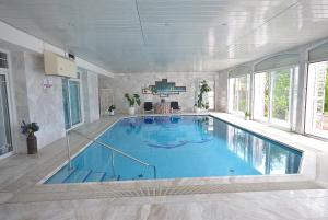 a large swimming pool in a large room with windows at Hotel Vila Margot in Herceg-Novi