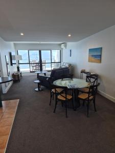 a living room with a table and chairs and a couch at 2 Room Luxury Beach Escape 112sq Mt Maunganui in Mount Maunganui