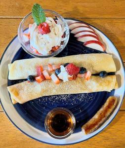 a plate with a sandwich with fruit and whipped cream at Auberge Foin de mer in Kamouraska