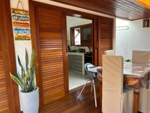 a dining room with a wooden door and a table at Casa Coruja - Taipu de Fora com Piscina in Marau