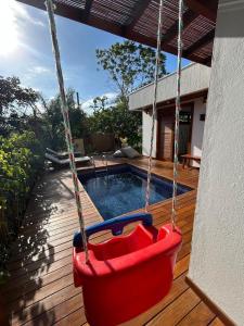 a swing hanging from a porch with a swimming pool at Casa Coruja - Taipu de Fora com Piscina in Marau