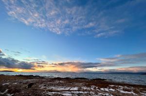 a person walking on the beach at sunset at Auberge Foin de mer in Kamouraska