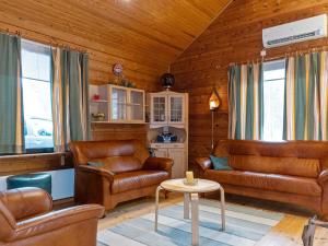 a living room with leather furniture and a table at Holiday Home Sallassi by Interhome in Salla