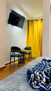 Una televisión o centro de entretenimiento en Hôtel Foham Oasis