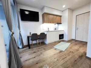 a kitchen with a table and chairs in a room at Panorama Tatry Apartment in Jezersko +3 photos