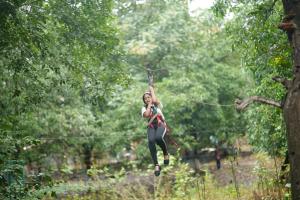 a woman is zip lining through the trees at Nivant Agro Experience in Gorhe