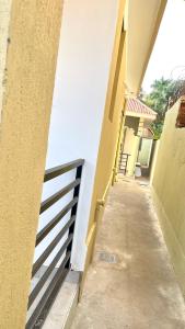 a hallway leading to a building with a fence at Spacious City Home in Kampala