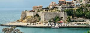 a castle sitting on top of a hill next to the water at Grandino rooms & apartments in Ulcinj