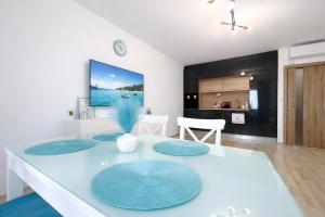 a living room with a white table with blue plates on it at Apartment Sea Sunrise, complex Carpe Diem, FREE PARKING in Balchik +36 photos
