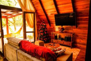 a living room with a couch and a christmas tree at Relaggio Chalet Encantado - Cristo Protetor in Encantado