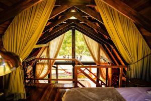 a room with a bed and a window with curtains at Relaggio Chalet Encantado - Cristo Protetor in Encantado
