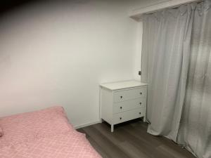 a bedroom with a pink bed and a white dresser at KM APPARTS 5 Wesel in Wesel