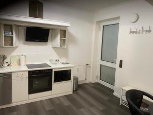 a kitchen with white cabinets and a large window at KM APPARTS 5 Wesel in Wesel +5 photos