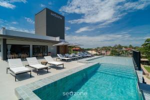 a swimming pool with lounge chairs next to a building at Studio in center of Rosa, rooftop w/ pool RSO0031 in Imbituba