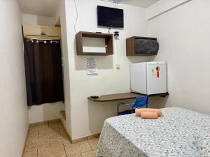 a small room with a table and a refrigerator at Hotel Consalter in Rodeio Bonito