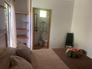 a bedroom with a bed and a bathroom with a toilet at Pumakari Rapa Nui in Hanga Roa +72 photos