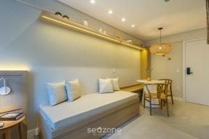 a small bedroom with a bed and a table at Studio in center of Rosa, rooftop w/ pool RSO0031 in Imbituba +7 photos