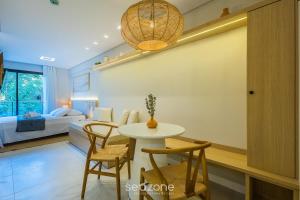 a room with a table and chairs and a bedroom at Studio in center of Rosa, rooftop w/ pool RSO0031 in Imbituba