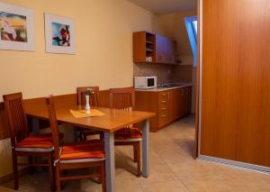a kitchen with a wooden table and chairs and a kitchen with a microwave at Vanilka in Liptovský Trnovec