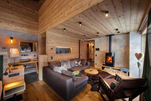 a living room with a couch and a fireplace at Mons Silva Private Luxury Chalets in Racines