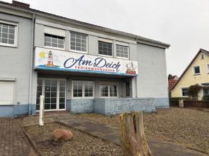 a building with a sign for an amlins delight restaurant at Monteurwohnungen Am Deich - Ideal für Langzeitaufenthalte in ruhiger Lage in Bremerhaven